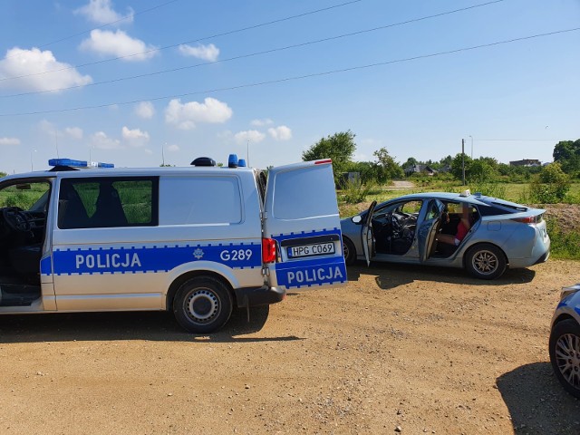 Policjanci zatrzymali 55-letniego kierowcę toyoty (w tle jego pojazd), który groził pieszemu bronią. Do zdarzenia doszło 13 czerwca 2021 w Brzegach na granicy gminy Wieliczka i Krakowa