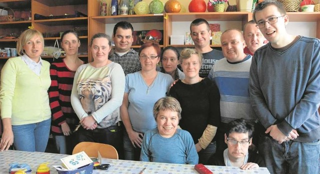Majka Jasek (w niebieskiej bluzce, siedzi na krześle) w otoczeniu przyjaciół w WTZ w Dobczycach