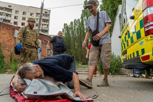 Mężczyzna przy zwłokach żony - ofiary rosyjskiego ostrzału pociskami Uragan w rejonie Charkowa, 7 bm. Trwa inwazja Rosji na Ukrainę