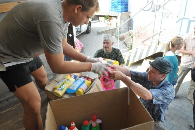Pracownicy Caritasu ładują paczki dla powodzian.