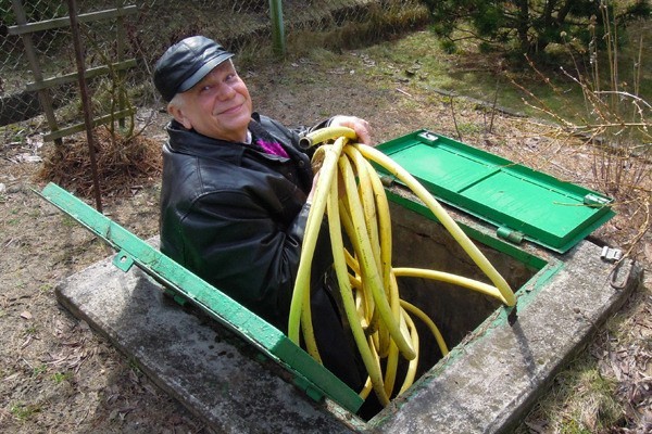 Jerzy Misiak, który ma działkę pod Konstantynowem, sprawdza przed włączeniem wody wodomierz, kran i węże.