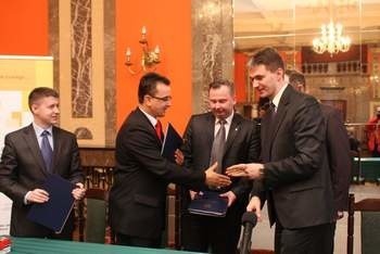 Od lewej: Burmistrz Włoszczowy Bartłomiej Dorywalski, wójt Iwanisk Marek Staniek i wójt Bliżyna Mariusz Walachnia otrzymują od marszałka Adama Jarubasa (z prawej) podpisane wstępne umowy na unijne dofinansowanie.