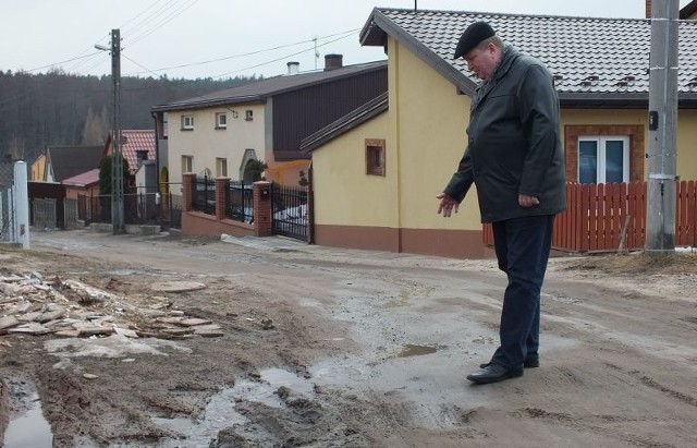 Ulice Polna, Przeskok i Zaułek od lat wyglądają tak samo: dziury, kałuże rozlewiska, a po ulicach &#8211; rwące rzeki. Na zdjęciu Jacek Gwóźdź pokazuje, z czym na co dzień muszą zmagać się mieszkańcy.