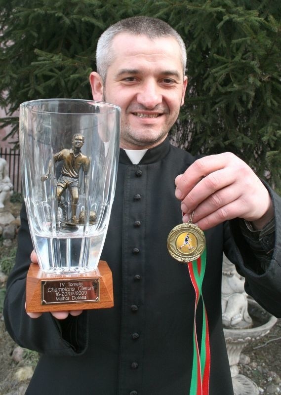 Ksiądz Dariusz Gałek z medalem i pucharem z Mistrzostw Europy Księży w Piłce Nożnej Halowej.