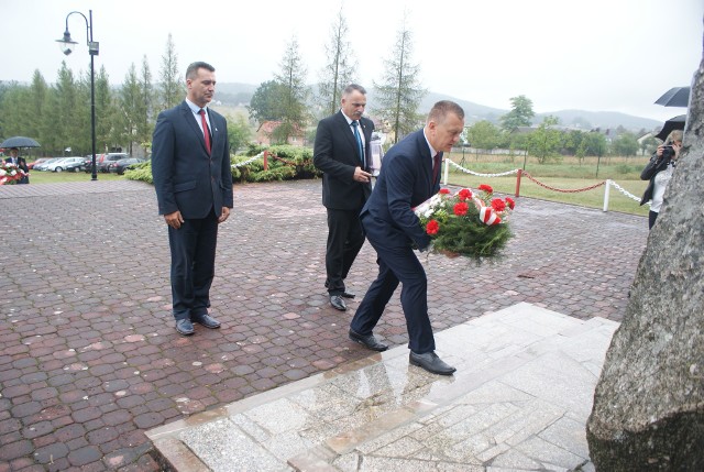 Na zdjęciu Rafał Gajos, radny Rady Miejskiej w Chęcinach, Robert Jaworski burmistrz oraz Tomasz Szczepanik, radny Rady Miejskiej w Chęcinach, składają kwiaty pod Pomnikiem Lotników w Gościńcu podczas niedzielnych uroczystości.