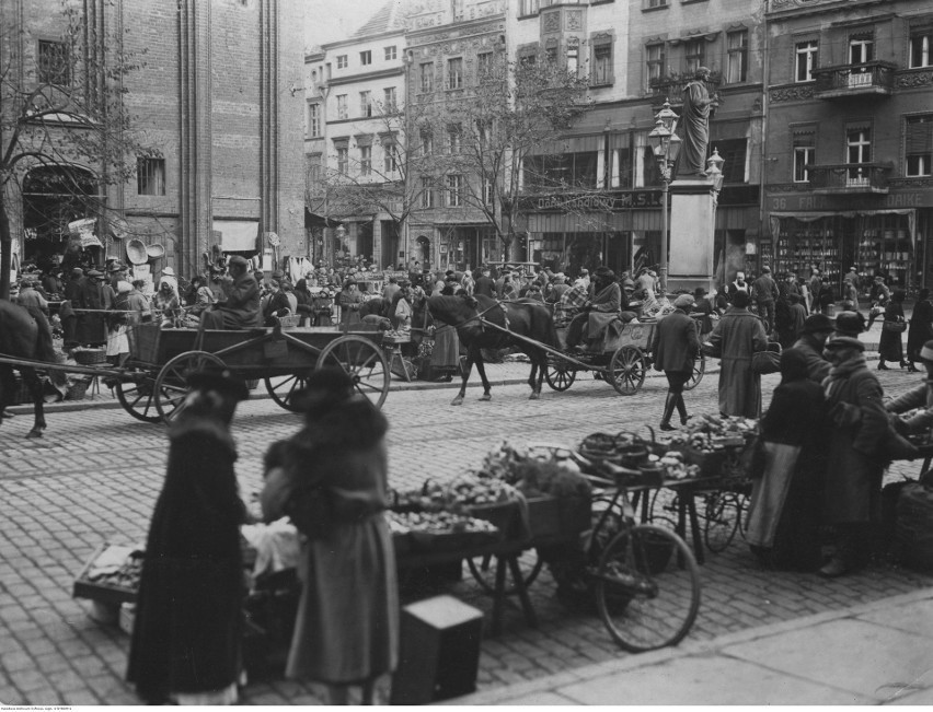 Opis obrazu: Handel uliczny na Rynku. W tle widoczny pomnik...