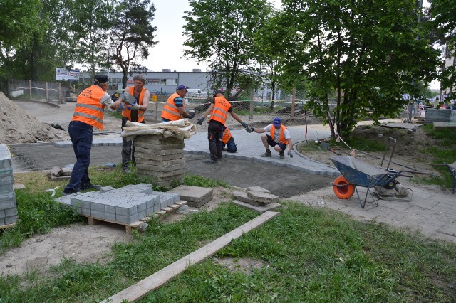 We wtorek pracownicy spieszyli się, aby ułożyć betonowe kostki na chodniku, którym dochodzi się do przejścia przez tory