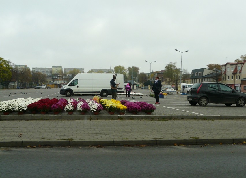 Cmentarz w Pabianicach 1 listopada. Znicz pali się pod bramą. Handlarze stoją... ZDJĘCIA