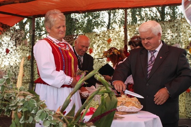 Wójt gminy Stanisław Barycki dzieli chleb ze starostą i starościną dożynek.