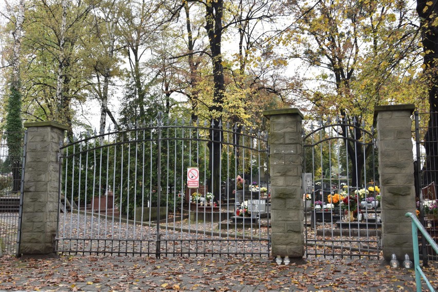Płoną znicze przed zamkniętą bramą cmentarza w Rybniku