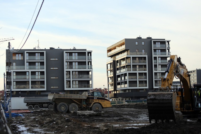 Kraków. Biurowiec wysoki na 17 metrów, bloki i przelotówka wśród zieleni