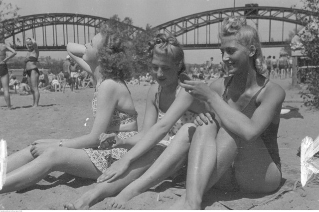 Zapraszamy na prawdziwą podróż w czasie. Upał od zawsze pchał ludzi do wypoczynku na plażach. Nie inaczej było przed laty. Polacy tłumnie odwiedzali jeziora, morze, a nawet brzegi rzek (które kiedyś były dużo czyściejsze, niż obecnie). Te zdjęcia są jak podróż w czasie.Na zdjęciach widzimy, że zmieniło się praktycznie wszystko. Zmieniała się moda plażowa, stroje zarówno kobiet, jak i mężczyzn. Zmieniały się też fryzury, co widać przede wszystkim po fryzurach uwiecznionych na zdjęciach pań. W oczy rzuca się jeszcze jeden szczegół - brak parawanów. Przed lat nikt ich nie używał mimo, że plaże były równie tłoczne jak obecnie.Zobacz też wideo: Upały to nie żarty.  Mogą być bardzo niebezpieczne dla naszego organizmu.  Jak chronić się przed gorącem?