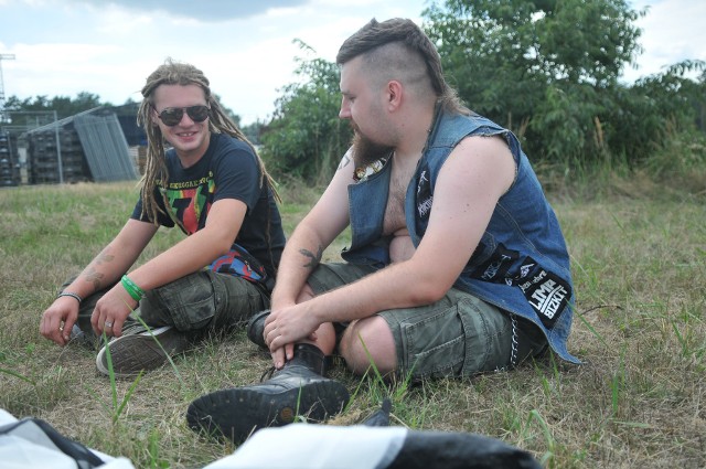 Do PolAndRock Festiwalu 2018 został nieco ponad tydzień. Tymczasem na woodstockowej łące w Kostrzynie z dnia na dzień przybywa namiotów. Ci, którzy już tu są szacują, że na polu może być nawet około 100 osób.Maćko przyjechał z Trzebnicy i jest w Kostrzynie już od około tygodnia. Spotkaliśmy go, gdy rozmawiał z Orzechem z Lubina. Chłopaki poznali się kilka minut wcześniej. - Tu nie ma z tym problemu. Przechodziłem, widziałem, że na polu rozbija się ktoś nowy i zaczęliśmy gadać - mówi Maćko. Nasz rozmówca twierdzi, że na polu może być już nawet około 100 osób. - Ale ich nie widać, jest straszny skwar, wszyscy rozbili się gdzieś w lasach - mówi. Orzech jest pierwszym, który rozbije swój namiot w pełnym słońcu. Rezerwuje miejsce dla znajomych, którzy mają przyjechać w kolejnych dniach. - Co roku rozbijamy się w tym miejscu - mówi. - Co można robić na tym polu na ponad tydzień przed rozpoczęciem festiwalu? - pytamy.- Na pewno nie ma nudy. Rozmawiamy, poznajemy nowych ludzi, ktoś gra na gitarze, wieczorem piwkujemy. Relaks i pełen luz - mówi Maćko.Na jakie koncerty czekają pierwsi woodstockowicze? Jednym tchem wymieniają nazwy zespołów Soulfly, Judas Preist, czy Hunter. Podwyższone ryzyko? - Bez sensu - mówią zgodnie. - Zawracanie głowy, utrudnianie życia organizatorom i więcej pracy dla służb porządkowych. Ale na szczęście woodstockowicze jakoś specjalnie tego nie odczuwają. Nie licząc tych nieszczęsnych barierek przed Dużą Sceną w zeszłym roku - mówią nasi rozmówcy.Wszystkie informacje o PolAndRock Festivalu 2018 (Przystanku Woodstock 2018) w Kostrzynie nad Odrą:  PolAndRock festival (Przystanek Woodstock 2018): koncerty, zdjęcia, filmy, informacje