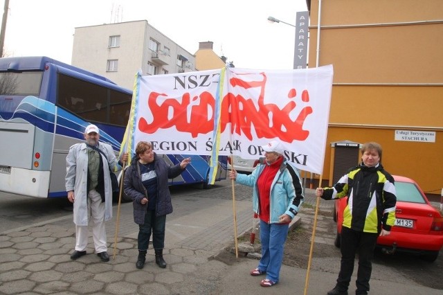 Manifestanci mają flagi Solidarności i transparent z szarfami w ukraińskich barwach.