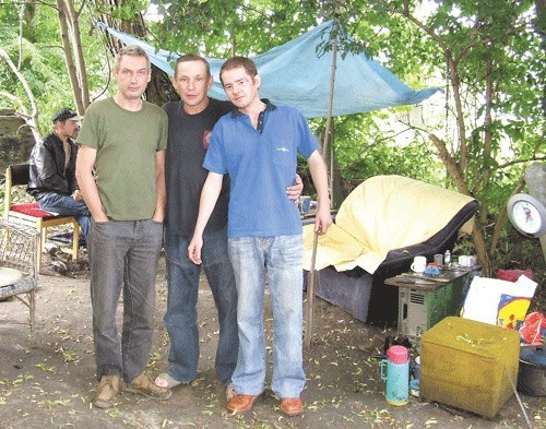 Trzej mieszkańcy obozu nad brzegiem rzeki. 