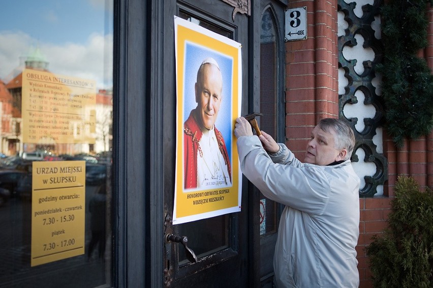 Adam Jaworski wiesza wizerunek Jana Pawła II na drzwiach ratusza w Słupsku