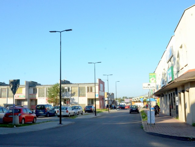 Ulica boczna odbiegająca od ulicy Okulickiego przy parkingu obok pawilonów handlowych