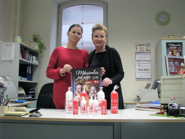 Katarzyna Paprocka i Iwona Kościcka z centrali Caritas Diecezji Opolskiej prezentują tegoroczne świece wigilijne - białe i czerwone.