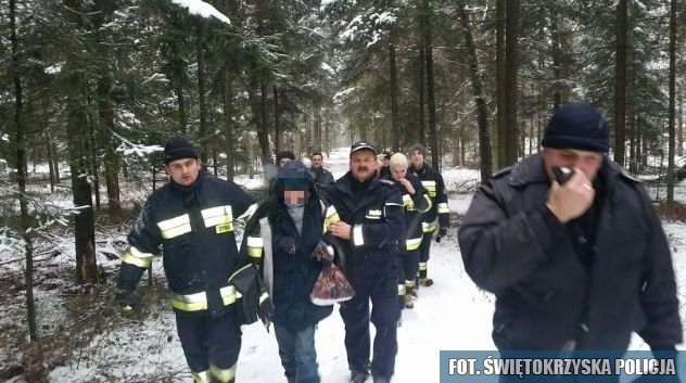 Strażak i policjant prowadzą do karetki odnalezioną, wychłodzoną 48-latkę