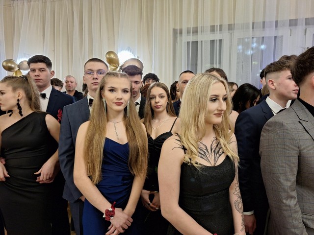 Studniówka 2024 II Liceum Ogólnokształcącego imienia Adama Mickiewicza w Skarżysku. Uczniowie w eleganckich strojach w oczekiwaniu na wielki bal.
