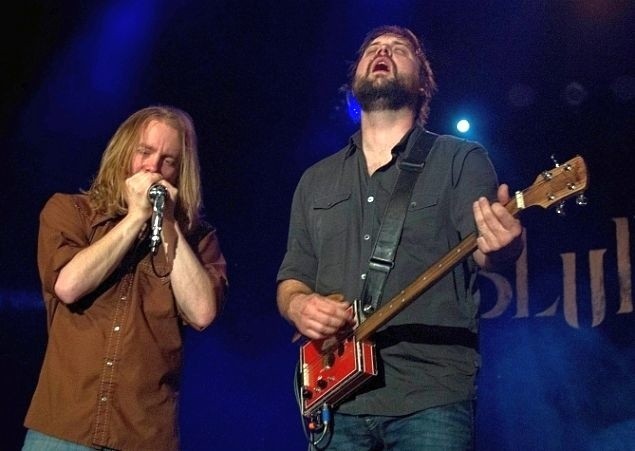 Dustin Arbuckle (harmonijkarz) i Aaron "Chainsaw" Moreland (gitarzysta) w raz z perkusistą rozpalą do białości kino Forum