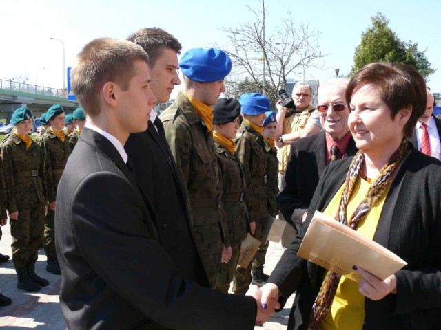 Poseł Renata Butryn i prof. Marian Marek Drozdowski wręczają dyplomy najlepszym uczniom.