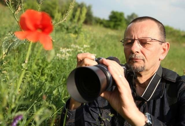 Piotr Frąckiewicz z aparatem fotograficznym w plenerze