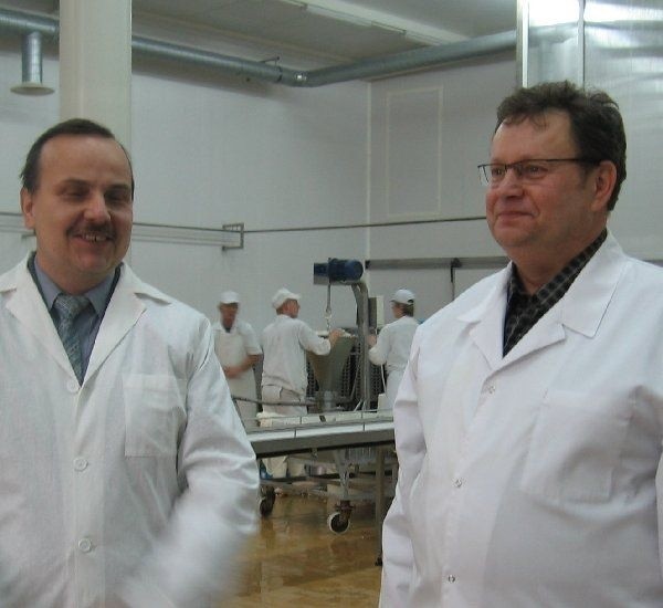 Robert Jadwiszczyk (od lewej) i Wojciech  Kalisz w nowej hali produkcyjnej. W tle  pracownicy przy stanowisku z twarogiem dla  cukierników.