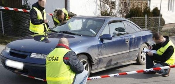 Funkcjonariusze dokonują oględzin samochodu, który poruszał się poszukiwany mężczyzna.