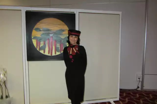 Joanna Bobrzyk podczas wystawy "Obrazy pocieszenia" na tle swojej pracy "Mamma"
