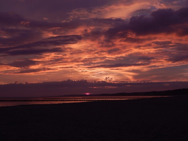 Słońce wschodzące nad ustecką plażą w czasie burzy