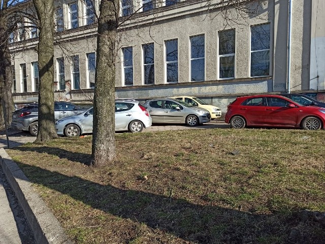 Auta na chodniku przy Instytucie Biopolimerów i Włókien Chemicznych w Łodzi, a wokół... puste strefy płatnego parkowania...