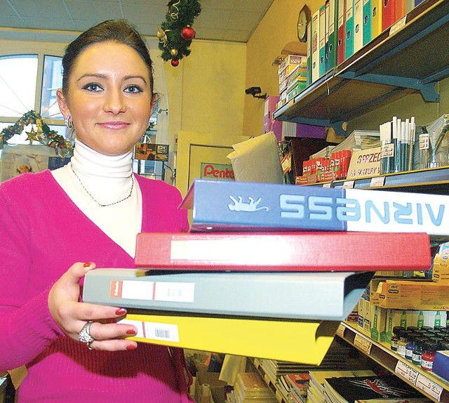 Marcelina Maślanka ze sklepu papierniczego "Ekierka&#8221; w Koszalinie pokazuje segregatory, które ułatwią nam uporządkowanie domowych rachunków.