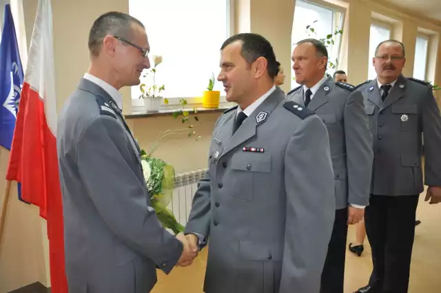 Marek Filipiak (z lewej) odbiera życzenia od współpracowników z komendy powiatowej w Szydłowcu.