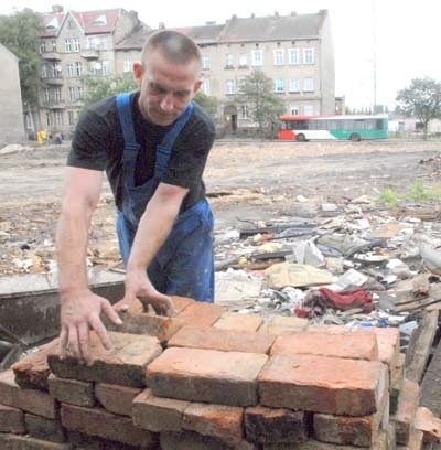 Robert Stańczak przygotowuje się do budowy ogrodzenia przy budynku, jaki odsłonił się po wyburzeniu rudery przy ul. Przemysłowej. Za nim pusta działka po ruderze.