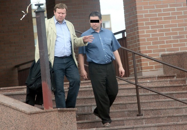 Inspektor Paweł C. (na zdjęciu z zasłoniętą twarzą, obok jego adwokat) został zatrzymany w czerwcu ubiegłego roku.