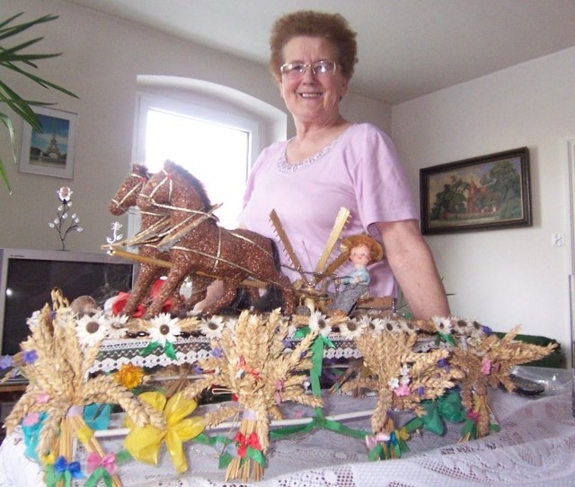 Jolanta Skorupińska od lat buduje wieńce dożynkowe z nasion i słomy. Ten na zdjęciu ma już prawie 20 lat. Obrazuje historyczną maszynę rolniczą &#8211; żniwiarkę, których pełno było kiedyś na polach.