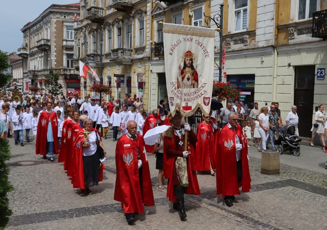 W czwartek w wielu miejscowościach regionu radomskiego przeszły uroczyste procesje Bożego Ciała. Największa z biskupem ordynariuszem Henrykiem Tomasikiem w Radomiu.ZOBACZ TAKŻE: Boże Ciało w Radomiu. Procesja przeszła ulicami osiedla XV-LeciaNa przodzie najczęściej szły dziewczynki w białych sukniach i sypały płatki kwiatów, a za nimi śpiewający pieśni religijne wierni z obrazami i figurami świętych. Trasy, którymi podążały procesje były udekorowane proporcami i kwiatami, a w oknach większości domów znajdowały się święte obrazki. Największej procesji w Radomiu przewodniczył ksiądz biskup Henryk Tomasik. Ta wyruszyła tuż po godzinie 10:30 z kościoła farnego. Uroczystej procesji przygrywała orkiestra wojskowa z Radomia. Ołtarze przy których prowadzone były modlitwy upamiętniały ciało i krew Chrystusa oraz symbolizowały czterech Ewangelistów: Mateusza, Marka, Łukasza i Jana. Podczas postojów czytane były fragmenty z każdej z Ewangelii, związane tematycznie z Eucharystią. Pięknie ozdobione ołtarze znajdowały się przy kościołach Świętej Trójcy, Ojców Bernardynów, Garnizonowym, a także przy Katedrze. Trasa wiodła ulicami Żeromskiego, Moniuszki i Sienkiewicza.Podczas kazania ksiądz biskup ordynariusz radomski Henryk Tomasik krótko odniósł się do bieżących spraw. Wspomniał między innymi o tym, że Ciało Chrystusa w obecnych czasach jest ranione nie tylko przez ludzi, ale również przez kapłanów. Stwierdził także, że jest atakowane, ponieważ jesteśmy świadkami wielu profanacji mszy świętej, czy procesji Bożego Ciała.