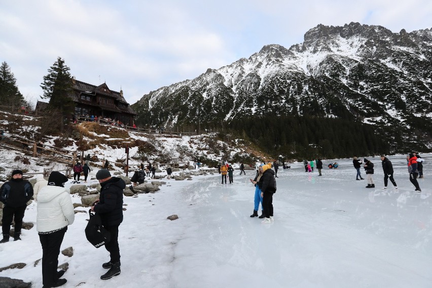 Turyści na tafli lodu na jeziorze Morskie Oko w Tatrach.