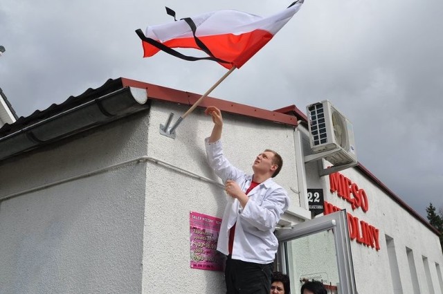 Mieszkańcy Szczecinka wywieszają biało-czerwone flagi przepasane kirem. Fot. Rajmund Wełnic