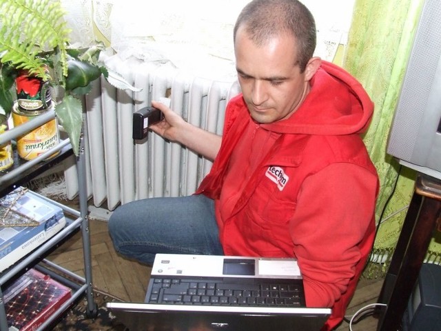 Pracownik firmy Techem, Dariusz Okiński, podczas odczytu i przeprogramowania podzielników ciepła w mieszkaniu pani Marianny.