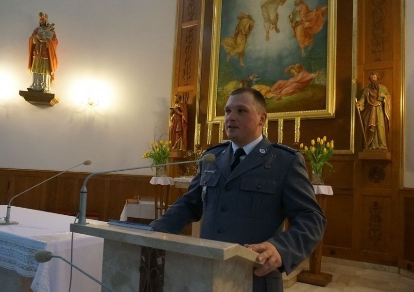 Asp. Krzysztof Stankiewicz rozdaje odblaski w kościele