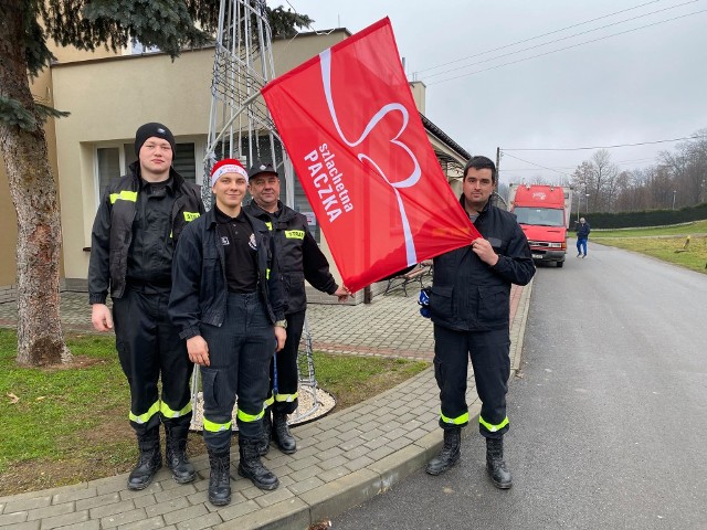 Druhowie z Ochotniczej Straży Pożarnej w Skowierzynie z flagą Szlachetnej Paczki