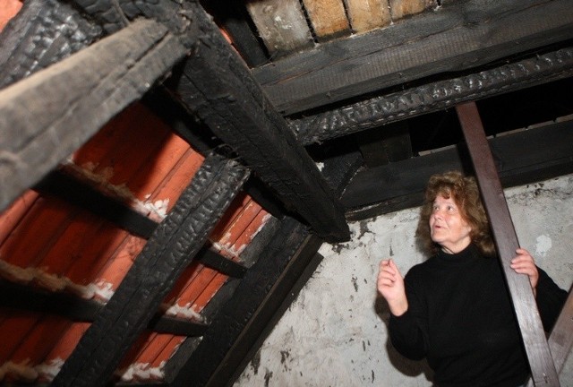 Eryka Mulik pokazuje belki na strychu, które paliły się ponad 40 lat temu. 