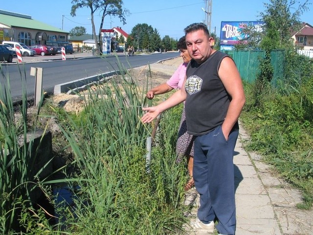 Piotr Kalinka pokazuje jeden z przepustów, który ze względu na zbyt małą moc przerobową, nie jest w stanie odprowadzić gromadzącej się na ulicy wody