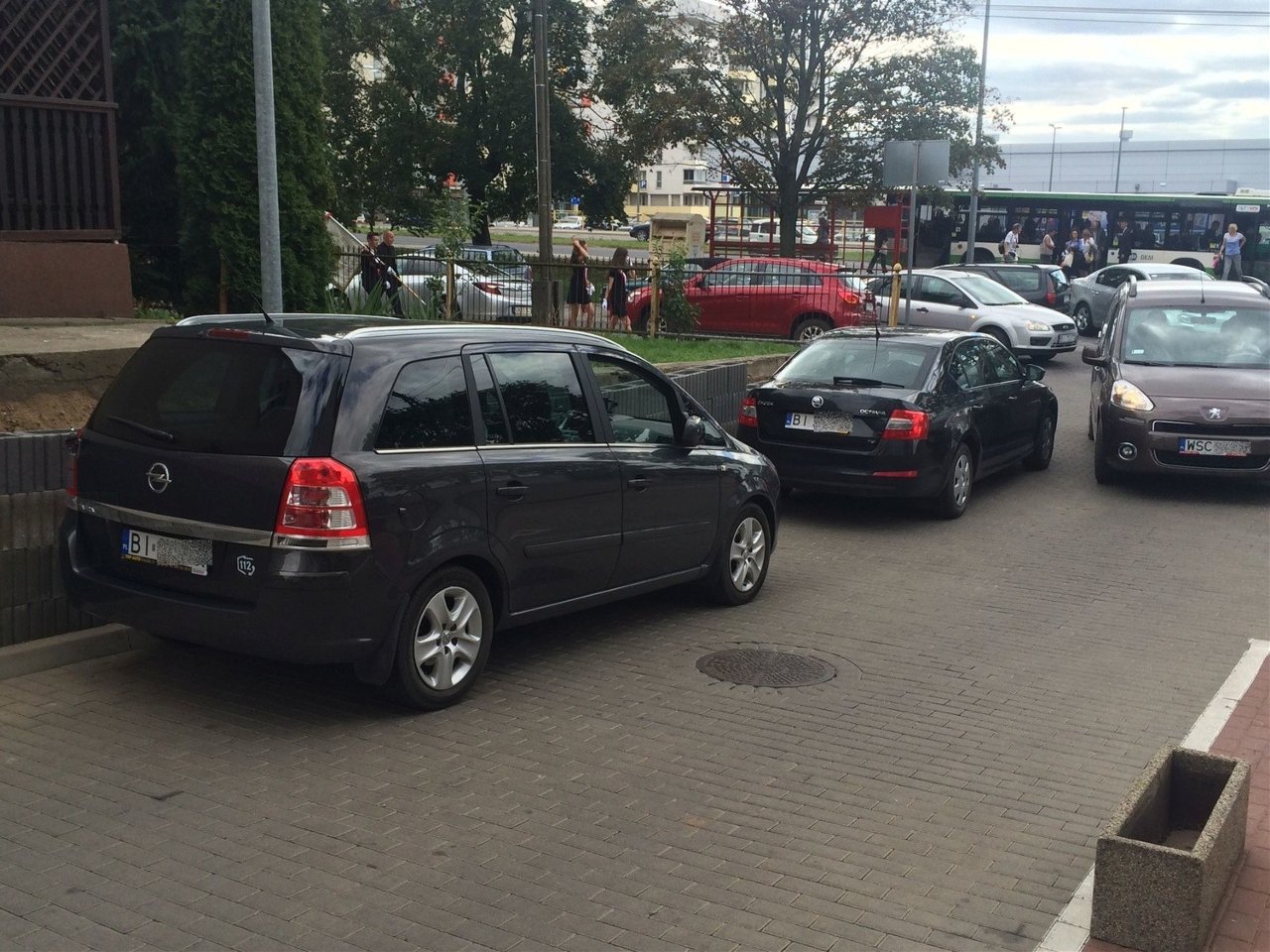 Powyższe zdjęcie przedstawia prywatny teren wspólnoty mieszkaniowej przy Al. Jana Pawła II 72 w Białymstoku a dokładnie zatarasowanie wjazdu na parking i zjazd do parkingu podziemnego.