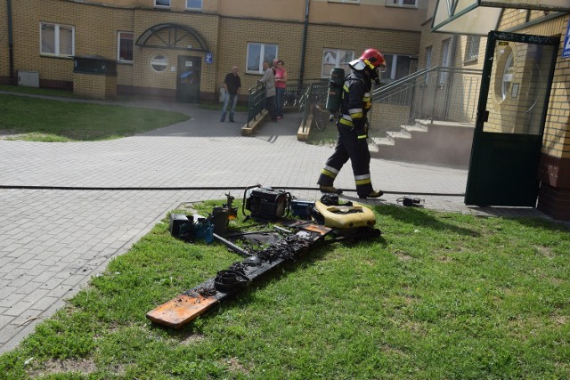 Strażacy wynoszą spalone przedmioty