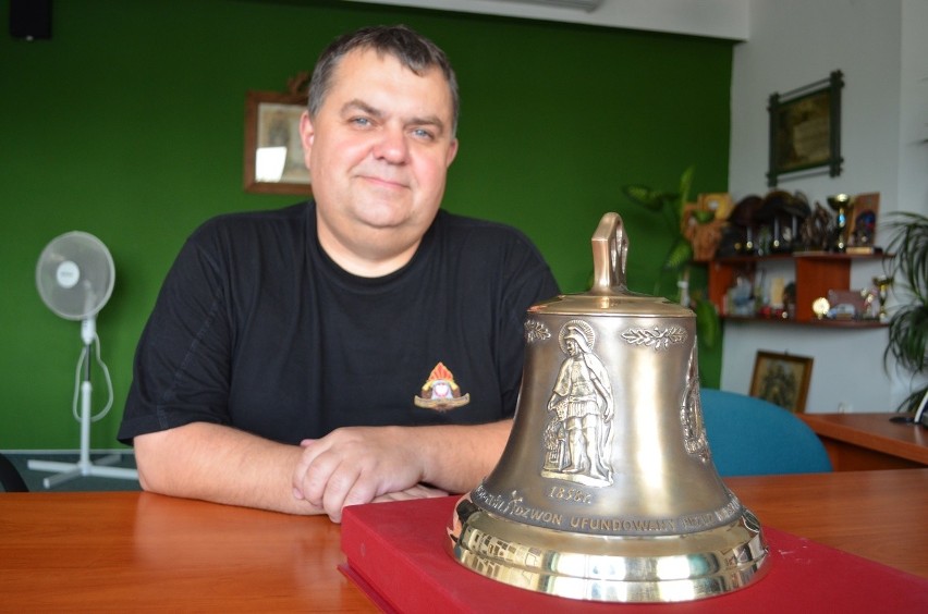 Komendant PSP Karol Skowroński prezentuje dzwon, którego ton...