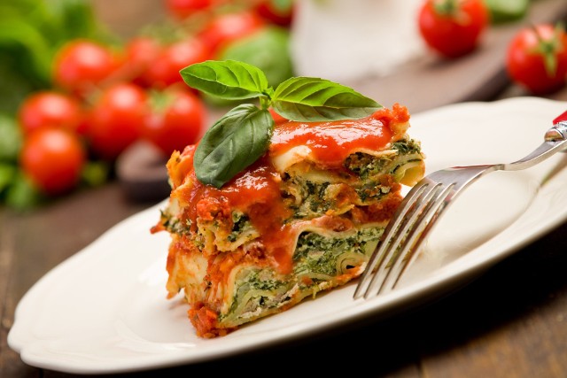 Domową lasagne ze szpinakiem można podawać polaną esencjonalnym sosem pomidorowym.