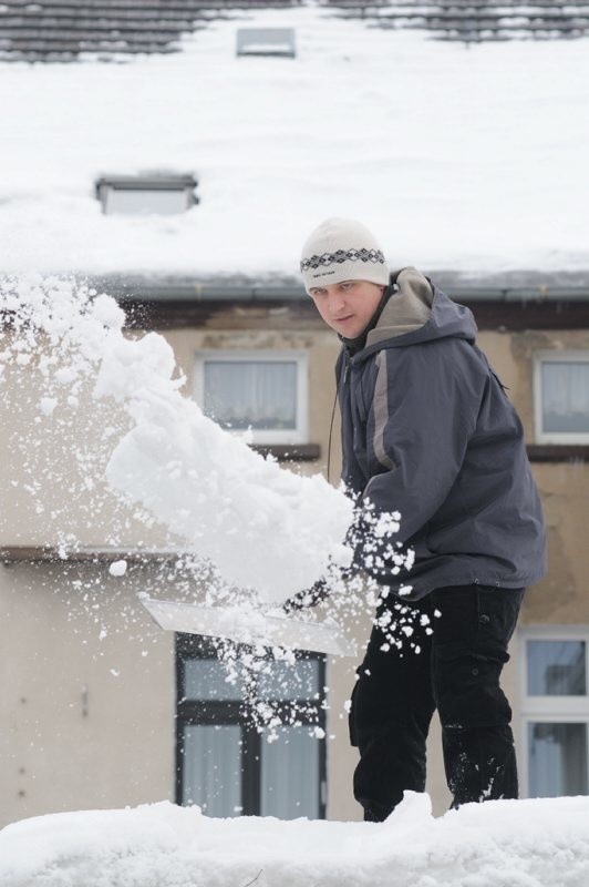 Na dachu garażu przy ul. Wałowej uzbierało się mnóstwo śniegu. Krzysztof Kamyszek nie chce dopuścić do zawalenia budowli.
